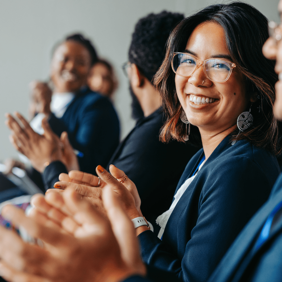 Group of people smiling and clapping in the front row